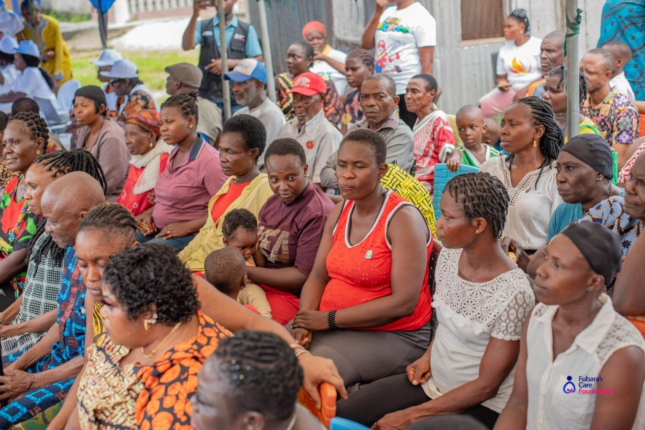 Community members of all ages seated together during the health education session at the Free Medical Outreach in Bakana