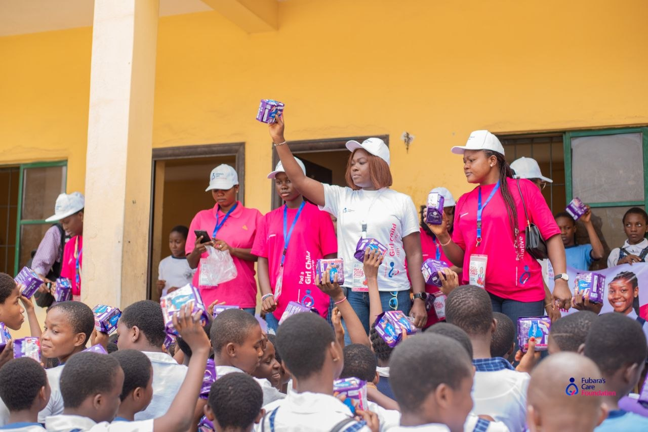Students reaching out for sanitary pad packs during the Pad a Girl Child Initiative at Elelenwo