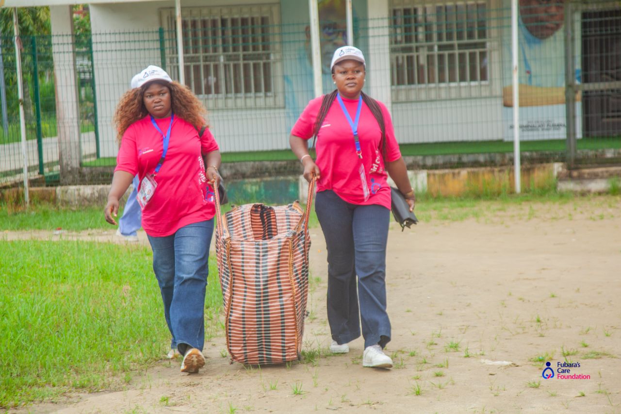 Volunteers carrying sanitary pad supplies into the school in Opobo Town