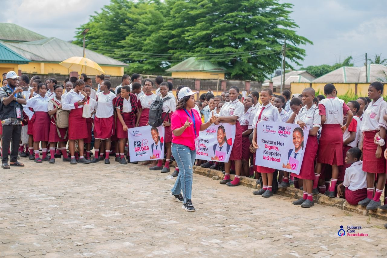 Students of Community Senior Secondary School, Akpajo holding 'Restore Her Dignity, Keep Her In School' and 'Every Pad Counts, Every Girl Matters' banners