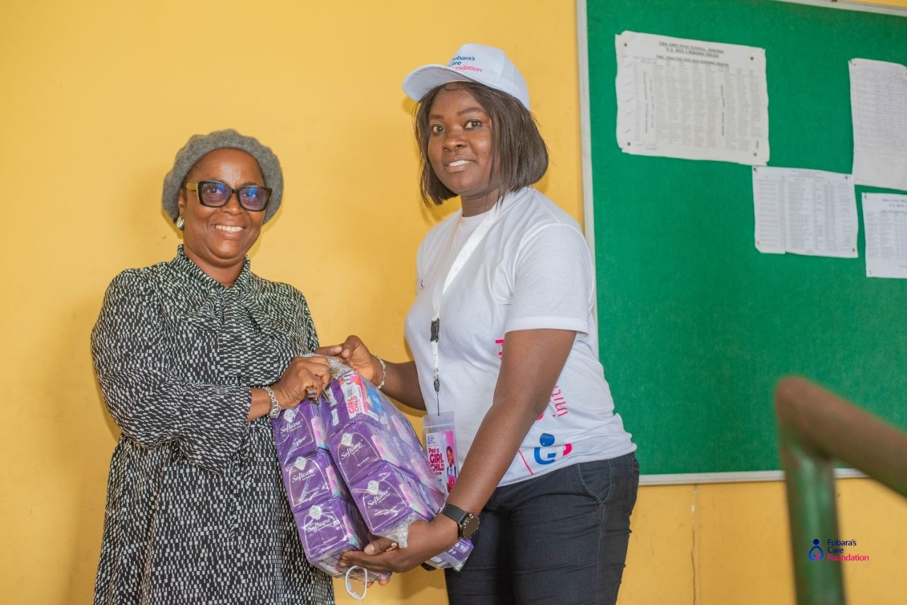 The Principal of Oba-Ama High School receiving sanitary pads from a Fubara's Care Foundation volunteer