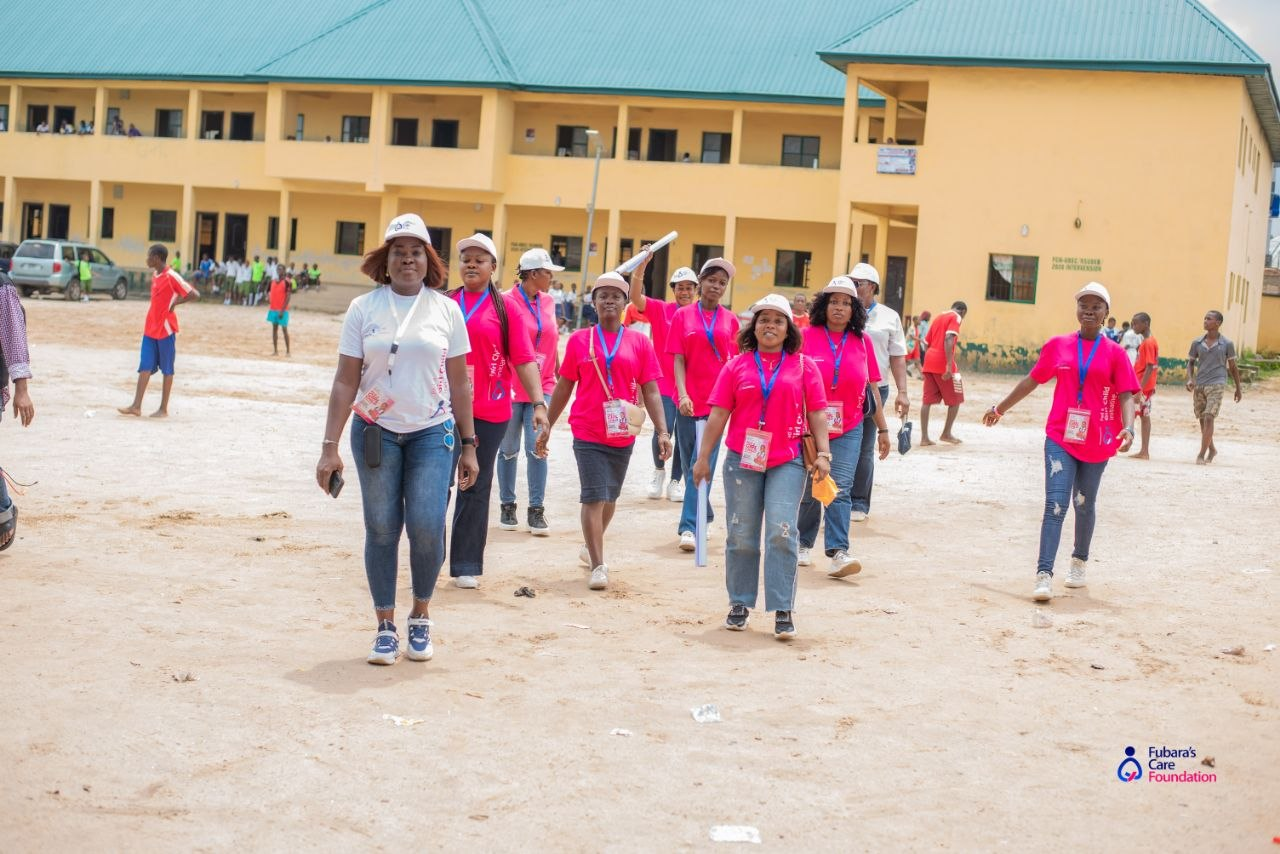 The Fubara's Care Foundation team walking across the Community Girls Secondary School, Elelenwo compound