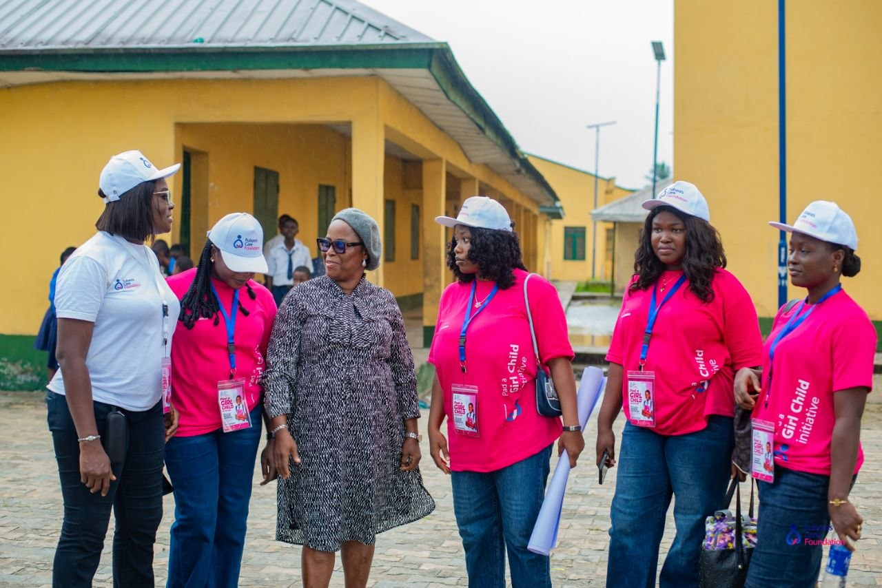 Fubara's Care Foundation team walking through the Oba-Ama High School compound with the Principal
