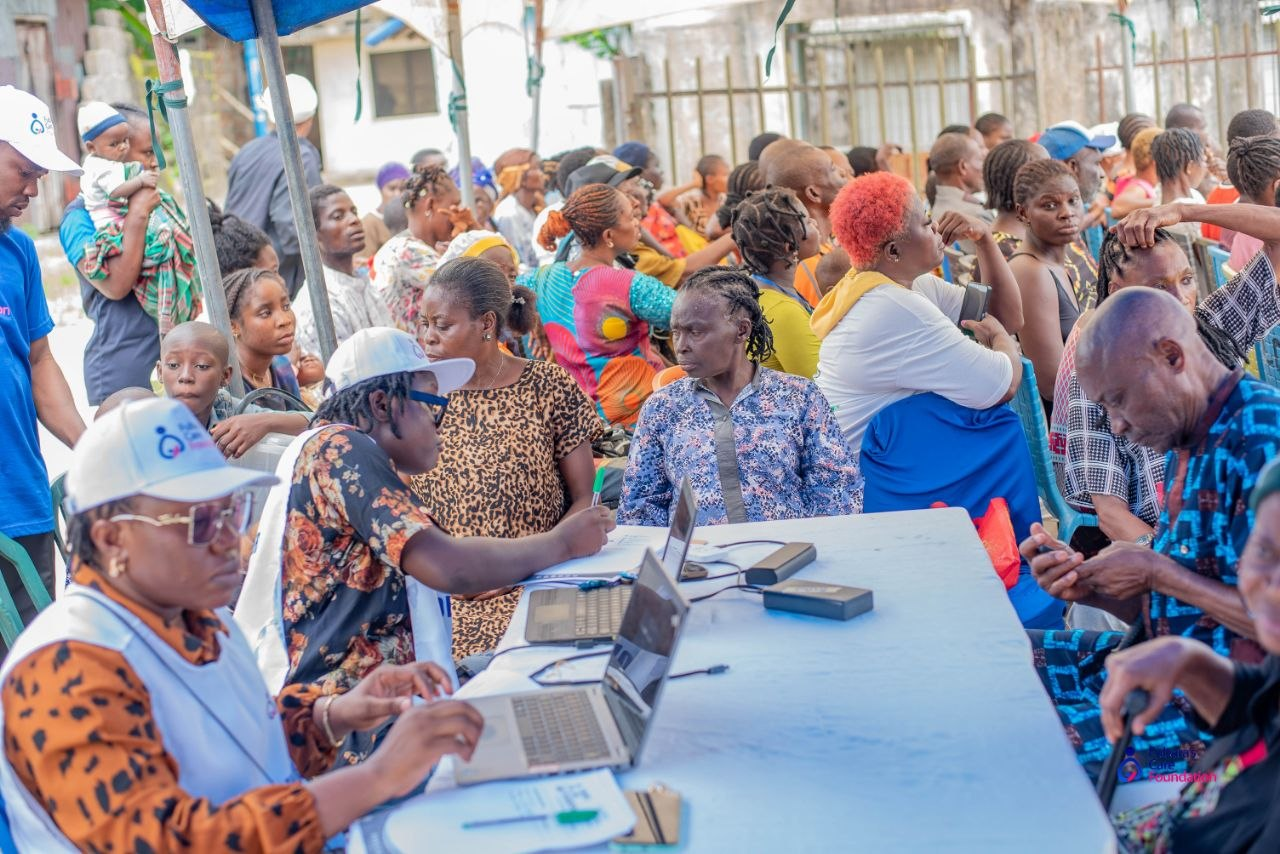 Volunteers registering patients at the reception desk as the community waits at the Bakana Free Medical Outreach