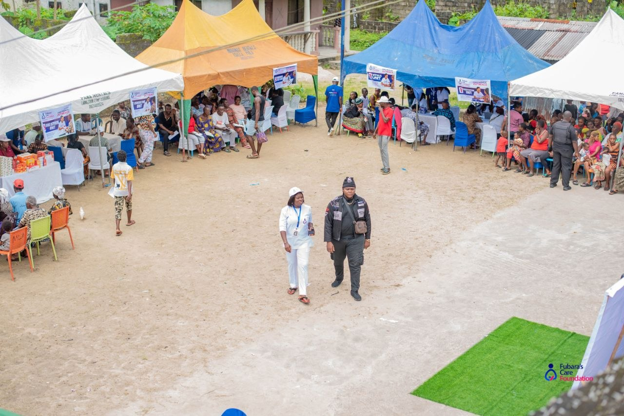 Aerial view of the Free Medical Outreach grounds in Bakana — registration, vitals, consulting and pharmacy tents filled with community members